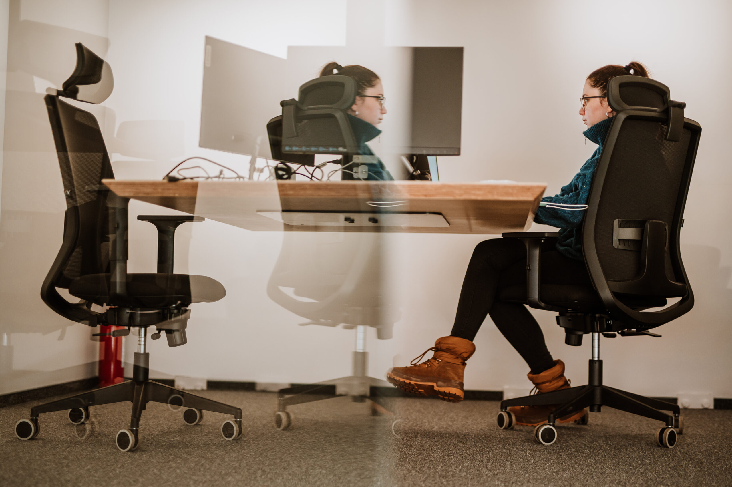 Two BetterQA colleagues working at desks facing each other across a shared table