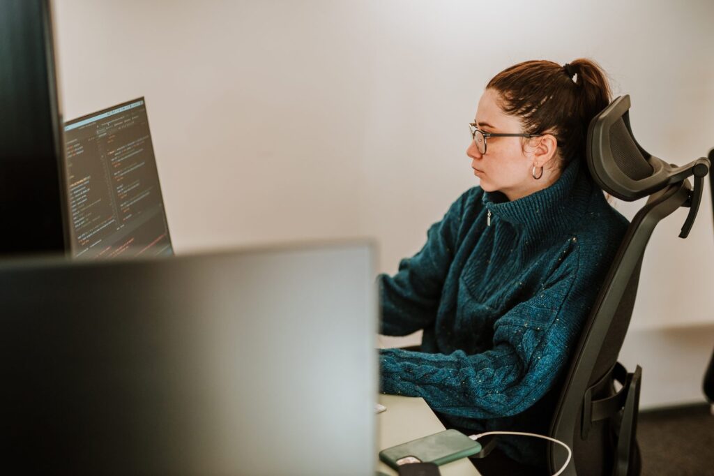 A BetterQA engineer looking at a code editor on her monitor