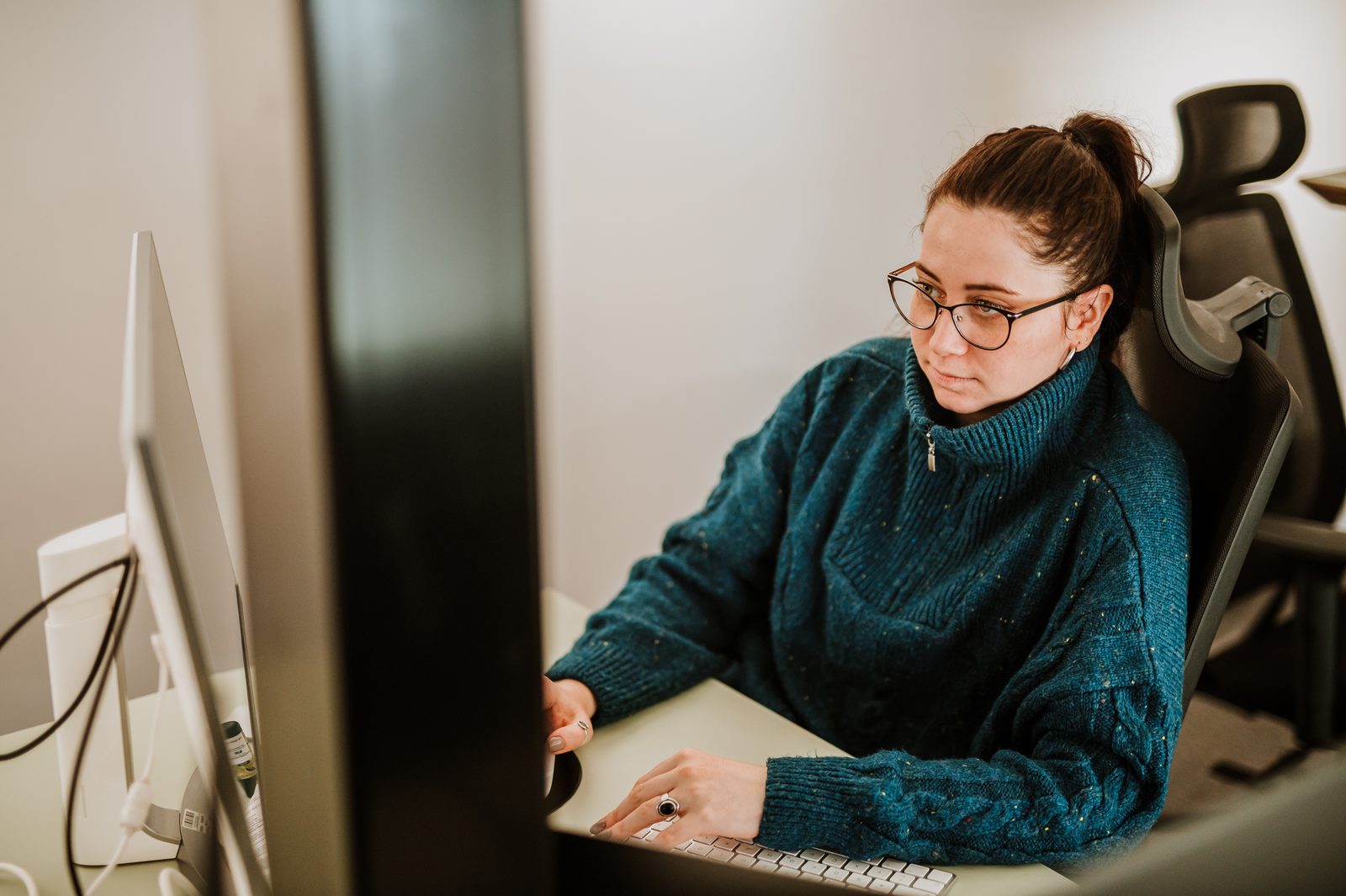 A BetterQA engineer reviewing a website on two monitors in the Cluj-Napoca office