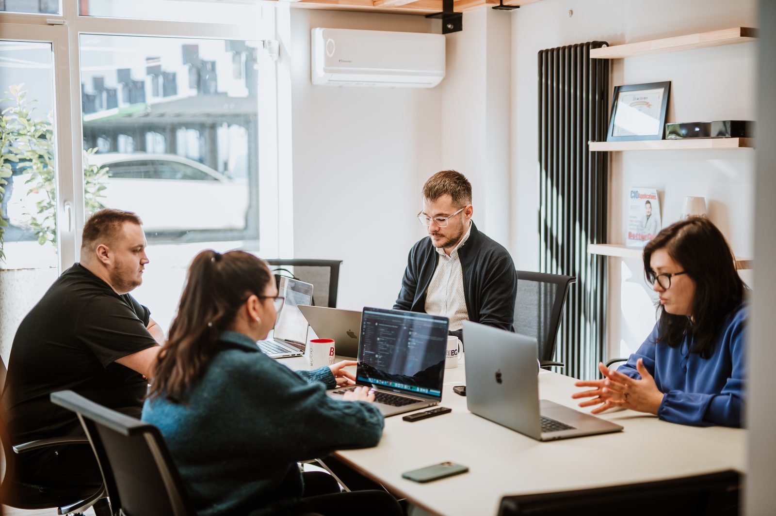 BetterQA engineers planning test work around a meeting table in the Cluj-Napoca office